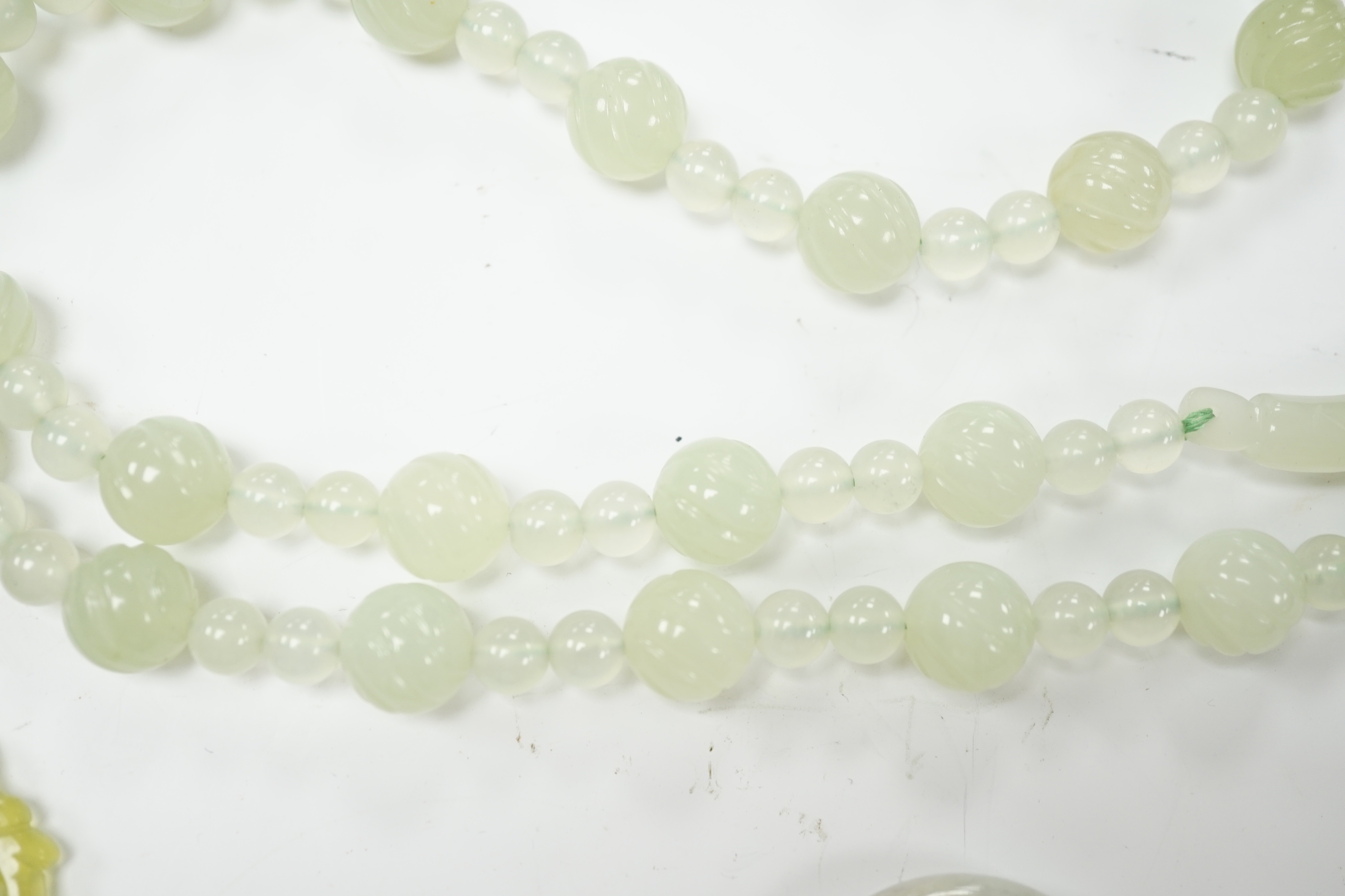 A bowenite jade bead necklace with dragon head clasp, circular pendant and carved disc